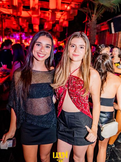Dos amigas posan abrazadas en un sector oscuro del local.